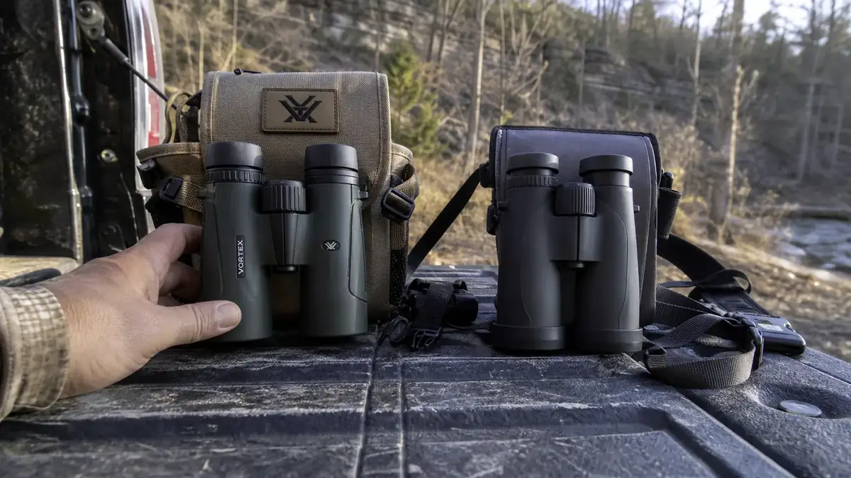 Vortex Crossfire HD 10x42 binoculars and Nikon Prostaff P3 10x42 binoculars set side by side on a truck tailgate